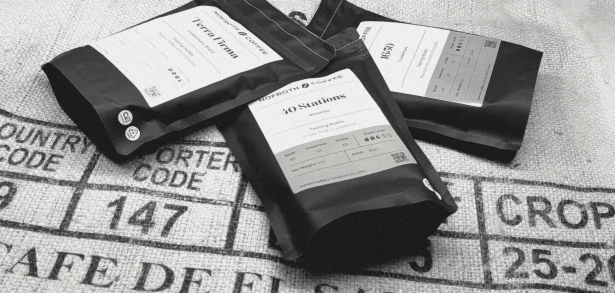 Black coffee bags with labels on a textured surface